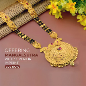 Close-up of a gold mangalsutra with black beads and red gemstone accents.