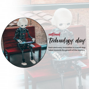 Robot sitting at a desk with a tablet, celebrating National Technology Day