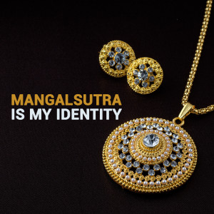 Close-up of a gold mangalsutra necklace and earring set with white stone detailing.