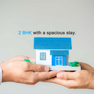 Hands holding a miniature house representing a 2 BHK property