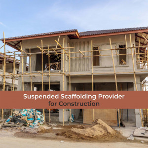 A house under construction with bamboo scaffolding and construction materials on the ground.