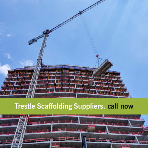 A tall building under construction with a crane lifting materials.