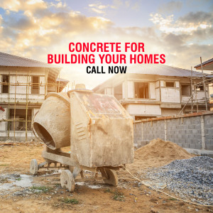 Concrete mixer at a construction site with a house under construction in the background