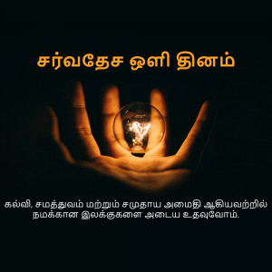 Hand holding a glowing lightbulb with Tamil text