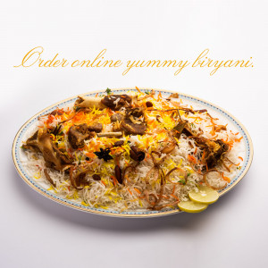 A plate of flavorful mutton biryani with rice, meat, and garnishes.