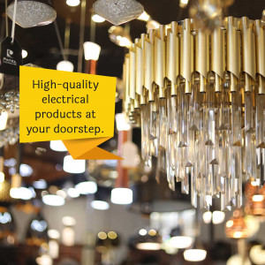 A display of various crystal chandeliers and lighting fixtures in a store, with a yellow text bubble promoting electrical products.