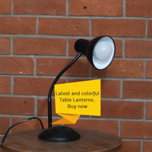 Black table lamp with a bright white bulb against a brick wall and a promotional sticky note.