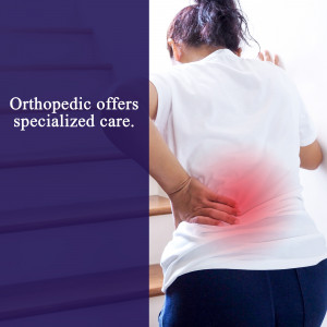 Woman holding her lower back in pain, representing orthopedic care.