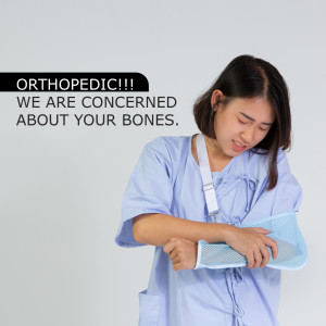 Woman with arm in a sling expressing pain, orthopedic concern.