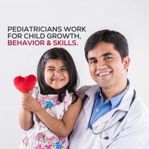 A pediatrician smiling with a young girl holding a red heart.