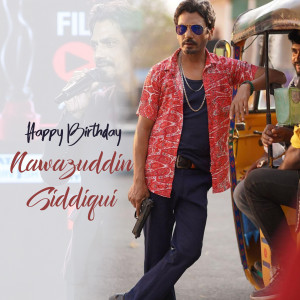 Nawazuddin Siddiqui posing in front of an auto-rickshaw with birthday greetings.