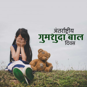 A sad little girl covering her face with her hands, sitting with a teddy bear in a field.