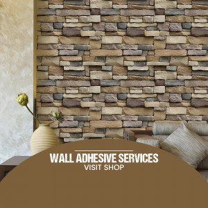 Close-up of a brick wall with an advertisement for wall adhesive services.