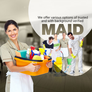 Woman holding cleaning supplies with other maids in the background