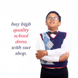 A young boy wearing a school uniform and looking upwards.