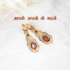 Close-up of ornate gold earrings with sparkling amber-colored gemstones