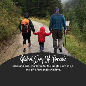 A family of three hiking on a dirt road through a forest.
