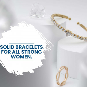 Close-up of a gold bracelet with sparkling stones on a white surface