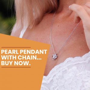 Close-up of a woman wearing a pearl pendant necklace with a silver chain.