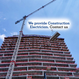 Construction site with a crane and building under construction, advertising electrician services.