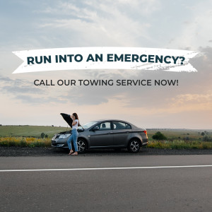 Woman standing by a car with the hood open, advertising a towing service.