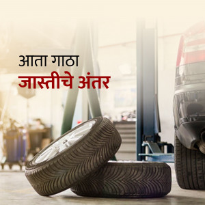 Car tires in an auto repair shop with text in Marathi