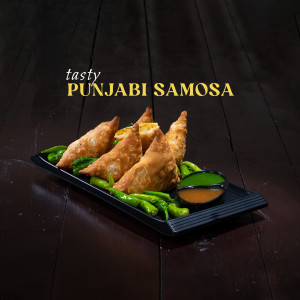 Close-up of golden-brown Punjabi samosas served with green chilies and chutney