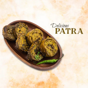 Close-up of Patra, a Gujarati snack, served on a wooden platter with a green chili.