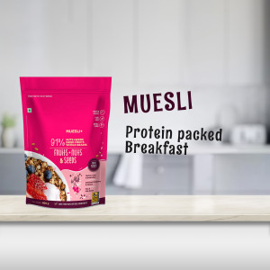 Pink muesli pouch with fruits and seeds on a wooden surface