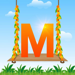Orange letter 'M' decorated with marigolds hanging from a wooden swing against a blue sky.