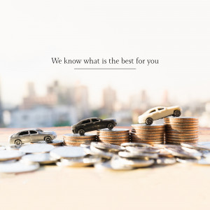 Toy cars on stacks of coins with a city skyline in the background, representing car investment and financial growth.