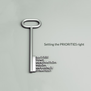 A silver key with words related to success and priorities written on it.