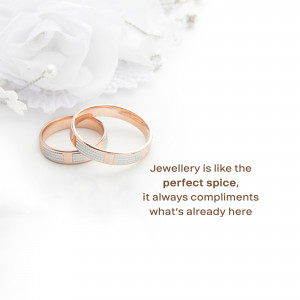 Close-up of two wedding rings, one gold and one silver, on a white fabric background.