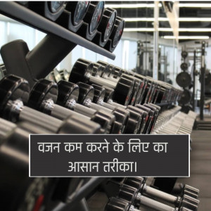 Rows of black dumbbells in a gym setting with text overlay in Hindi.