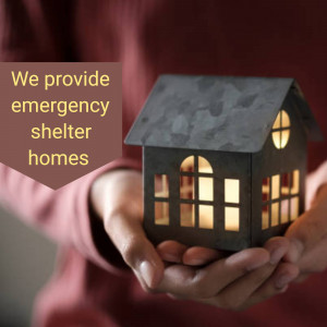 Hands holding a decorative house with a glowing light inside, representing emergency shelter.