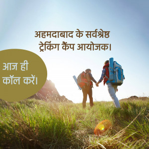 Couple hiking in a grassy field with backpacks, promoting a trekking camp in Ahmedabad.