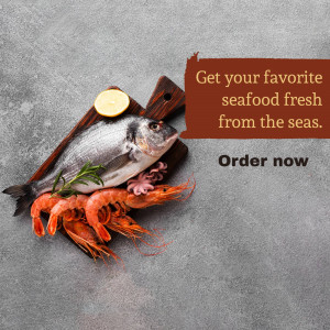 A beautifully arranged platter of fresh seafood including fish, shrimp, and lobster on a wooden board.