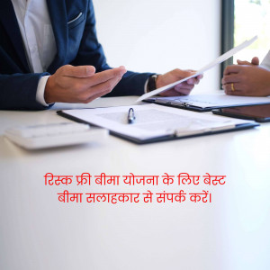 Two people discussing documents at a table, likely an insurance consultation.