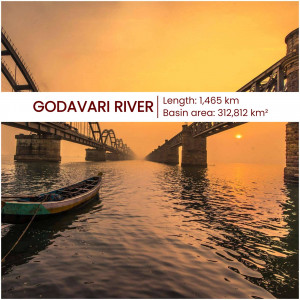 A scenic view of the Godavari River with a bridge and boat at sunset.