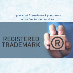 Hand holding wooden blocks with 'Registered Trademark' and trademark symbol