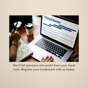 Laptop displaying trademark information with a person writing in a notebook