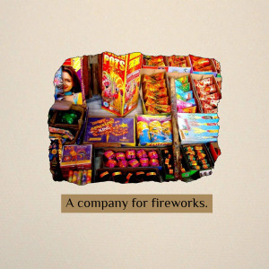 A colorful display of fireworks boxes in a small shop with a person visible in the background.