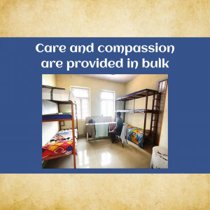 A dormitory room with bunk beds and a person sitting on a bed.