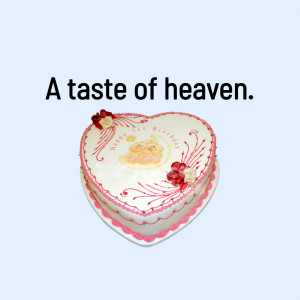 A heart-shaped white birthday cake with floral decorations and a teddy bear design.