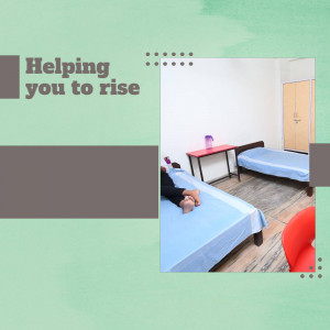 A well-lit dormitory room with two beds and a small table.