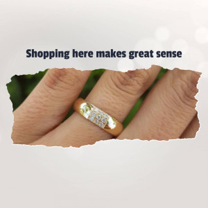 Close-up of a gold ring with diamonds on a finger