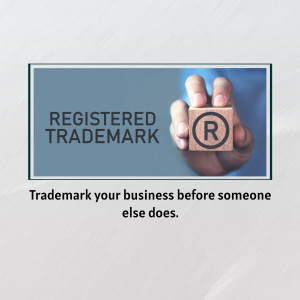 Hand holding a wooden block with a registered trademark symbol