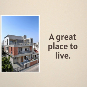 Exterior view of a modern three-story house with a garden and fence.