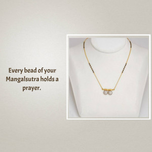 Close-up of a delicate gold and black bead Mangalsutra necklace on a white mannequin.