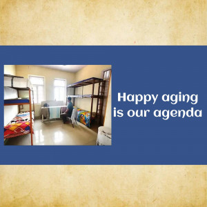 Interior view of a room in a senior living facility with bunk beds and a person sitting at a desk.